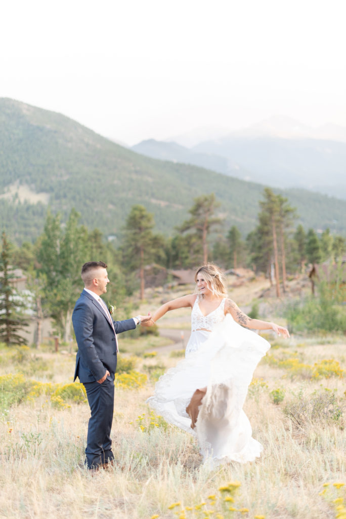 Estes Park, Colorado summer elopement bride and groom portraits twirling in a field 