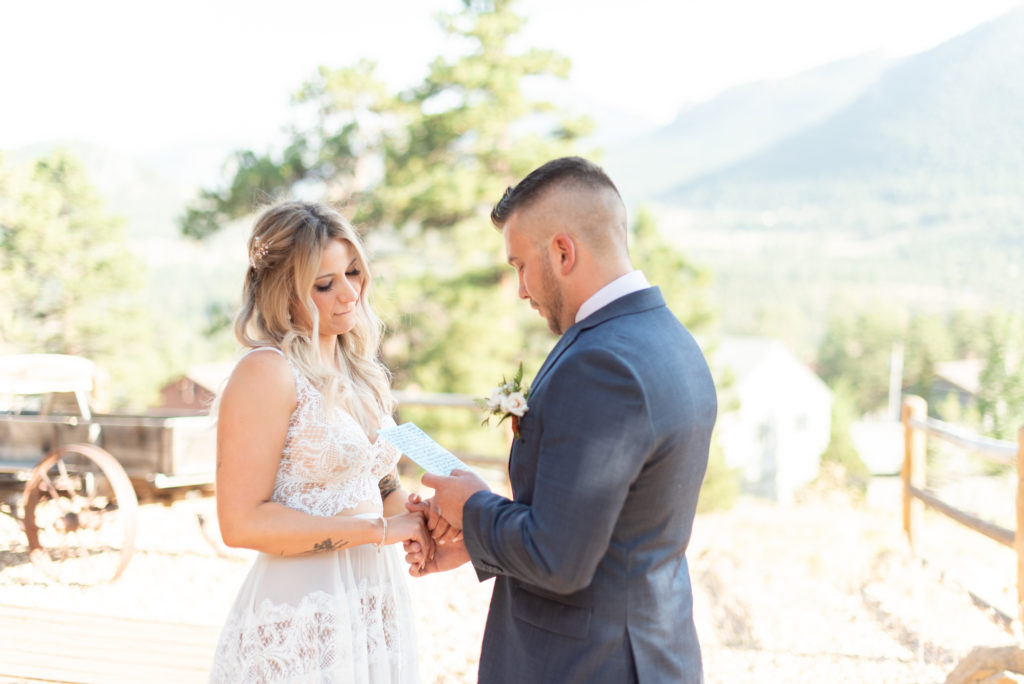 Estes Park, Colorado summer elopement bride and groom read vows during first look